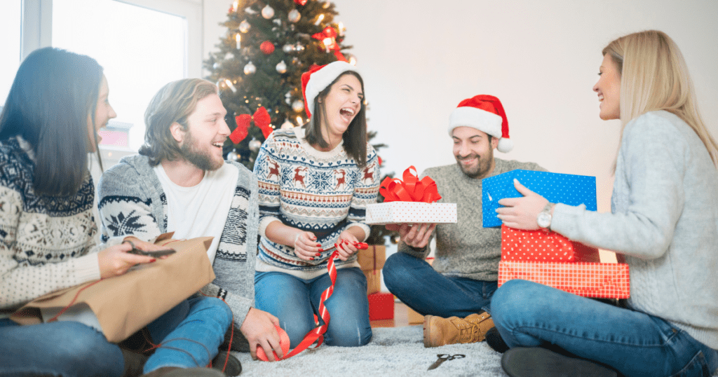 Friends laughing and enjoying a Secret Santa gift exchange