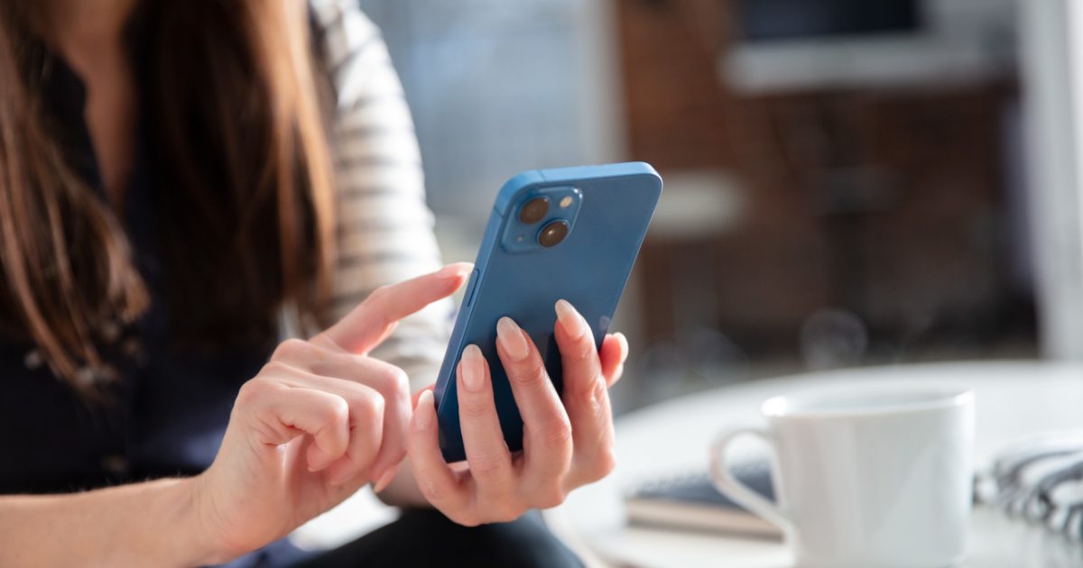 A woman using the iPhone reminders app on her phone